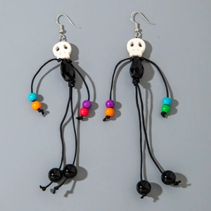 Detail of beaded skull tassel earrings with resin bone and black faceted bead accents