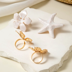 Ensemble de bagues fleurs et étoile de mer dorées avec détails en émail blanc