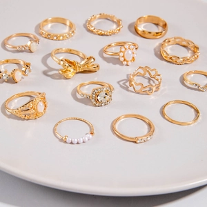 Set detallado de 14 anillos dorados con diseños de mariposas, perlas y cristales