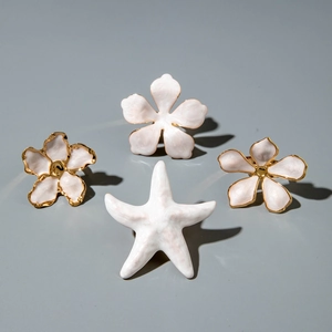 Ensemble de bagues en métal avec fleurs en émail blanc et détails d'étoile de mer