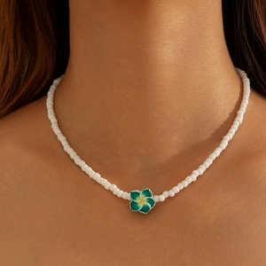 Detail of beaded resin flower necklace on model's neck for bohemian summer beach style