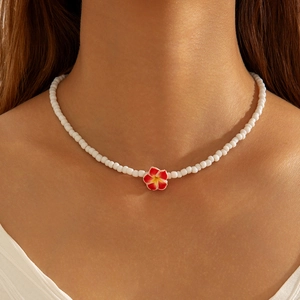Bohemian frangipani flower beaded necklace with resin petals on female model's neck