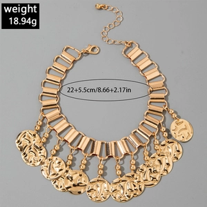 Detail of vintage gold anklet with embossed coin charms and tassel leaf accents