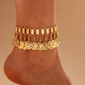 Detail of bohemian gold anklet featuring hammered coin charms on a flat chain