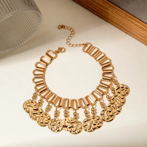 Detail of gold leaf fringe anklet featuring hammered coins and rectangular chain links