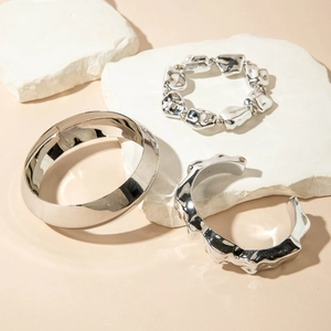 Vue détaillée de bracelets métalliques argentés aux textures lisses et fondues