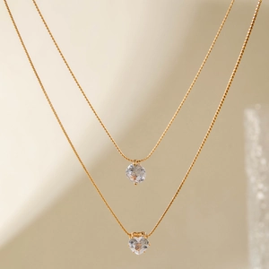 Elegant gold double-layered necklace featuring sparkling round and heart crystal pendants