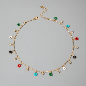 Detail of bohemian gold chain necklace with colorful enamel charms and small rhinestones