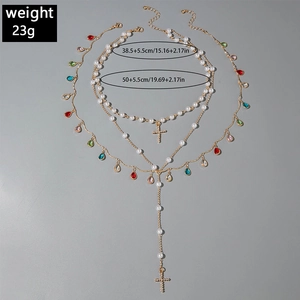 Detailed view of layered gold necklace with colorful crystals and pearl chain