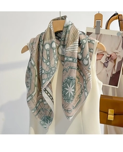 Detail of silk scarf with geometric chain pattern draped over white summer outfit