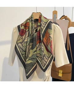 Detail of silk square scarf featuring elegant leaf print in rust and moss green tones