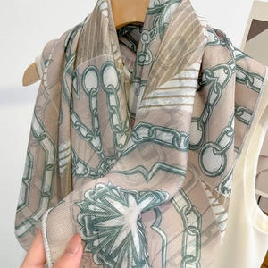 Elegant chain pattern silk scarf hanging on a wooden hanger with modern geometric print
