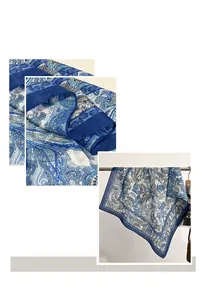 Detailed close-up of blue paisley silk scarf showing precise machine-stitched edges