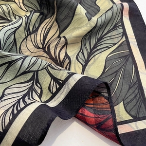 Lightweight square silk scarf with elegant green tropical leaf print and soft texture