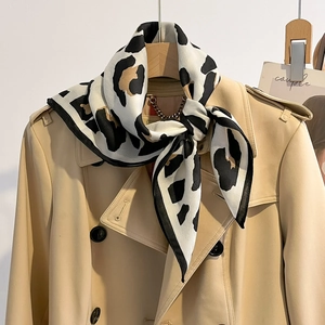 Chique zijden sjaal met luipaardprint elegant gecombineerd met een beige trenchcoat