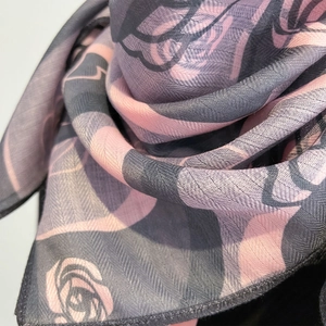 Detail shot of the floral rose pattern on pink and grey linen-feel silk neck scarf