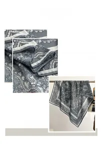 Détail d'un foulard en soie à motif paisley gris avec des bords ourlés à la machine fins