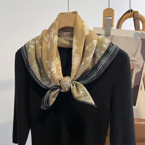 Retro golden silk square scarf with floral print styled on a black knit sweater
