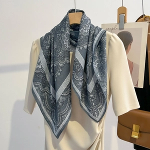 Carré classique en coton et lin à motif paisley bleu porté sur un haut en maille beige
