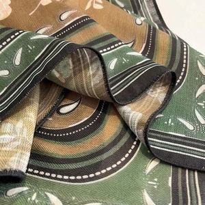 Detailed macro view of vintage paisley print and texture on a retro green silk scarf