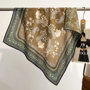 Vintage paisley print silk scarf in brown and sage green, styled with a fashion magazine