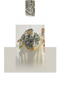 Close-up of delicate floral embroidery on a white cotton linen neck scarf with yellow trim