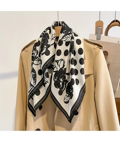 Polka dot and black floral silk scarf layered on a classic trench coat for fashion