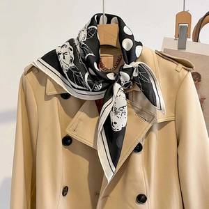 Polka dot and floral silk scarf styled on a trench coat for elegant fashion looks