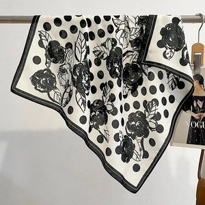 Polka dot and black rose pattern silk scarf hanging on a rack for a stylish look