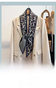 Détail d'un foulard patchwork léopard et pied-de-poule sur un blazer beige