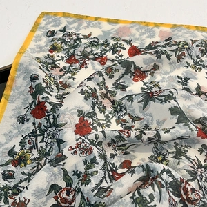 Macro detail of retro floral silk scarf showing intricate poppy prints and delicate texture