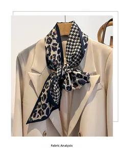 Détail d'un foulard en soie léopard et pied-de-poule noué sur un blazer beige chic