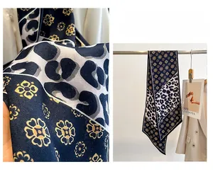 Détail d'un foulard étroit en soie à motif léopard et floral avec bordures cousues