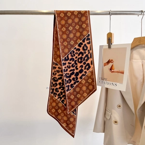 Détail d'une écharpe étroite à motif léopard et floral portée sur un blazer beige