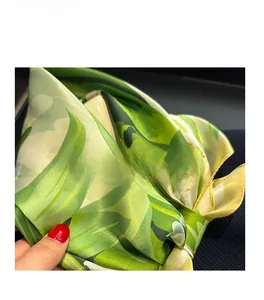Gros plan d'un foulard en soie imprimé montrant le drapé doux et les motifs floraux