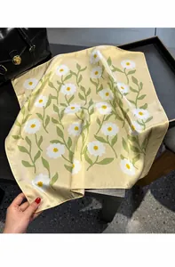 Detailed view of 100% mulberry silk scarf with daisy floral print and smooth texture