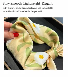 Detail of premium 100% mulberry silk scarf with yellow daisy print and satin finish