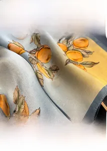 Detailed close-up of fine hemmed edges on a floral mulberry silk scarf with a glossy finish