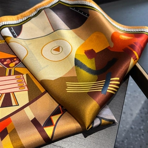 Detailed close-up of a geometric print silk scarf showing soft satin texture and fine stitching