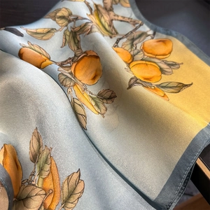 Macro view of floral silk scarf showing premium mulberry silk texture and botanical fruit art