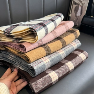 Detailed view of various plaid patterns in thick soft cashmere-like winter scarves