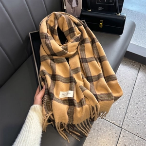 Detailed view of ginger and brown plaid cashmere-like scarf with fringe and elegant tag