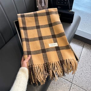 Detailed shot of yellow and dark green plaid cashmere scarf with soft tassels