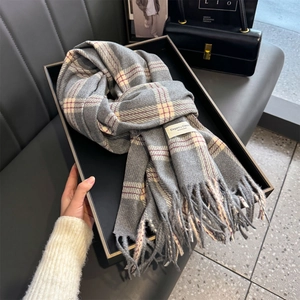 Classic grey plaid cashmere scarf with tassel edges on a premium fashion display