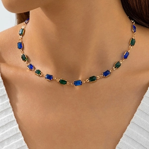 Close-up of vintage choker featuring rectangular blue and green crystals on gold chain