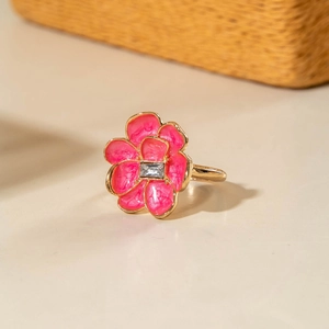 Dettaglio macro dell'anello a fiore in smalto rosa con cristallo rettangolare e oro