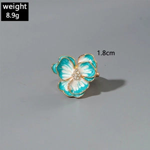 Dettaglio dell'anello a fiore in smalto blu e bianco con bordi dorati e misure indicate