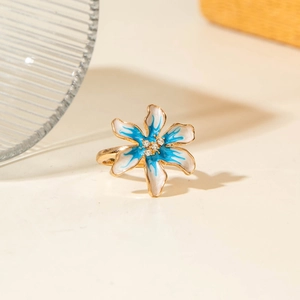Dettaglio anello camelia con smalto blu e bianco e zirconi scintillanti al centro