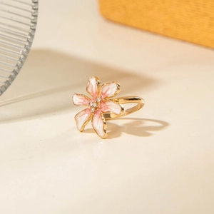 Dettaglio macro dell'anello a camelia con petali sfumati rosa e finitura dorata