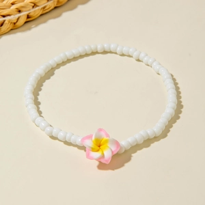 Detail of bohemian beaded anklet with resin plumeria flower and white round beads